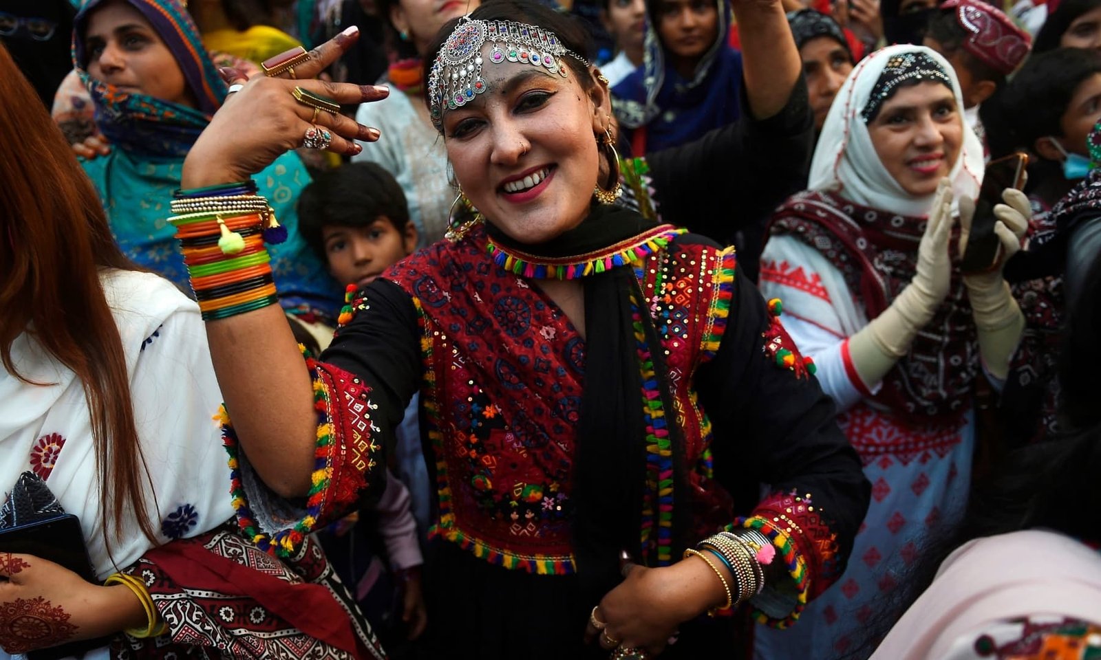 Happy Sindhi woman in colorful embroidered dress during culture day celebration