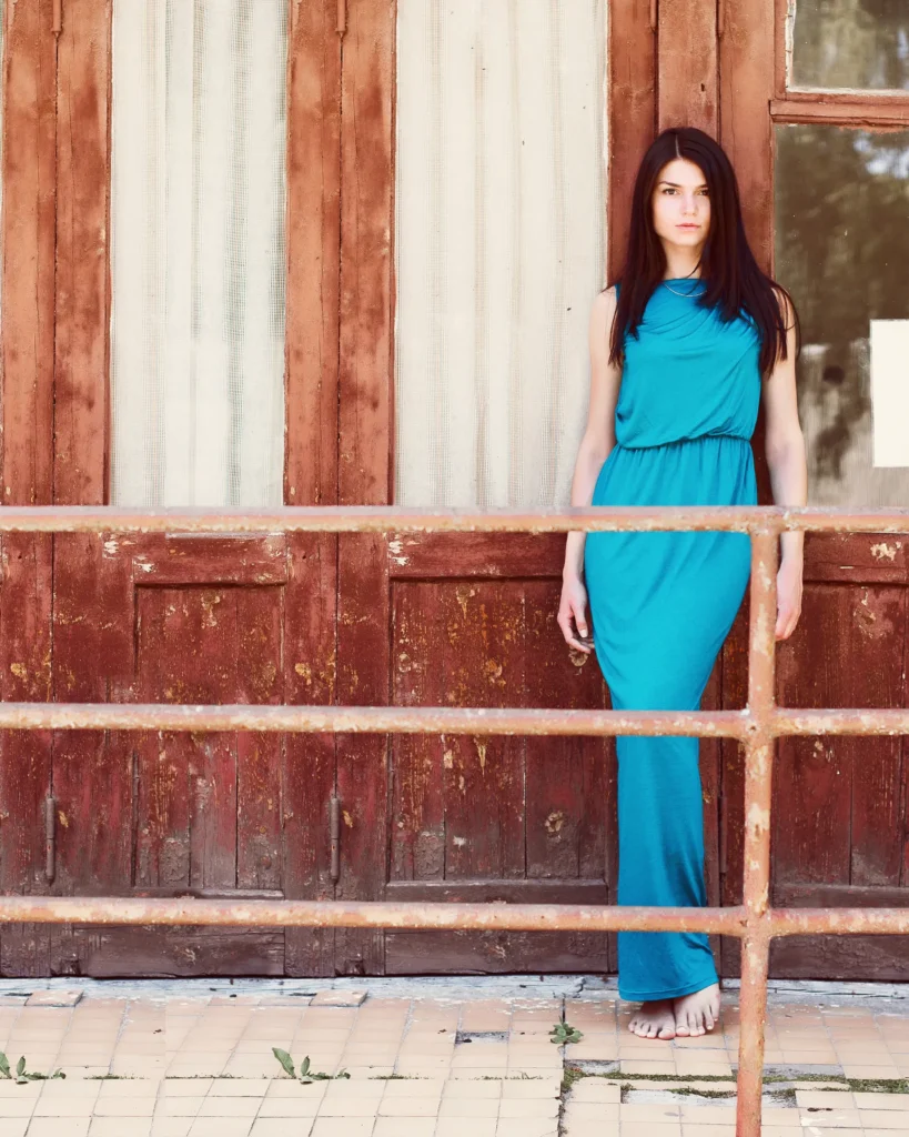 Stylish woman posing confidently in front of a rustic wooden facade building